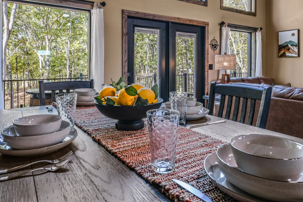 Inside the home, an inviting dining area is flooded with natural light from expansive windows. The scene features a dining table ready for a family breakfast, emphasizing a seamless, homelike transition from arrival to relaxing indoors.