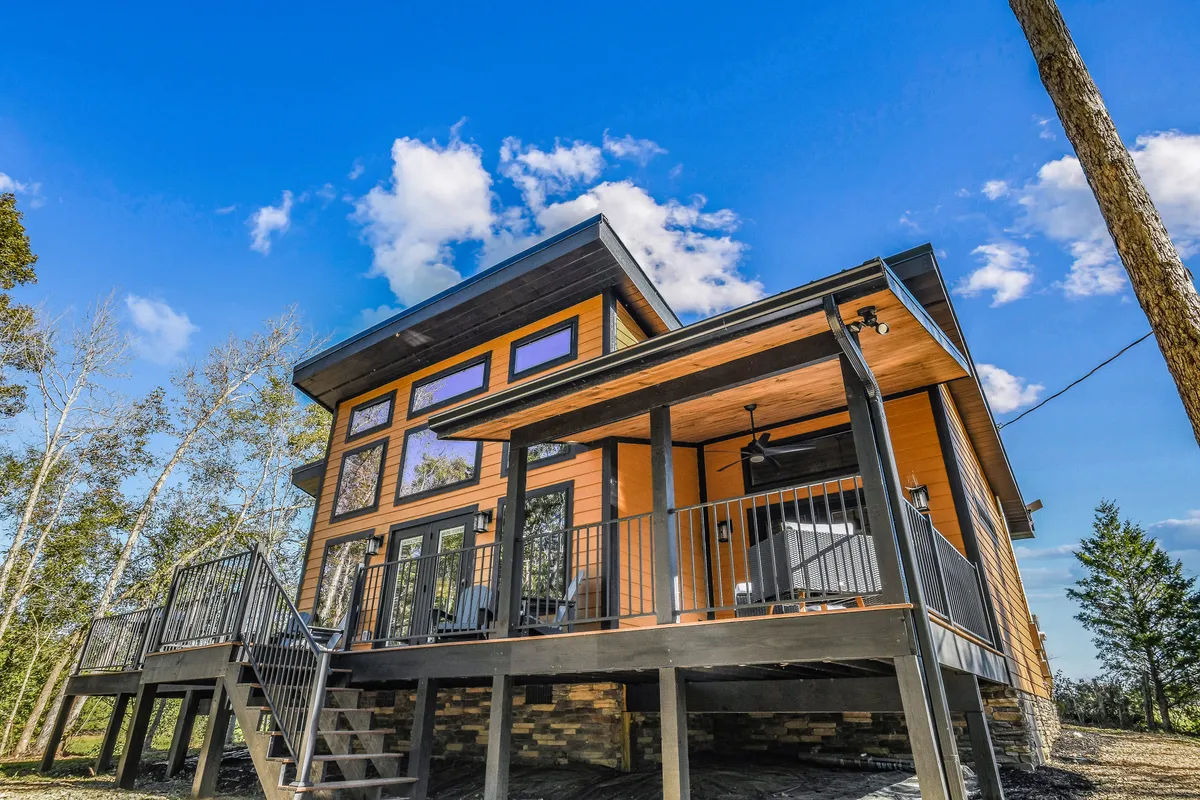 This image captures the inviting deck area of the property, highlighting its modern architectural style, large windows, and the seamless integration with the natural environment. The setup is perfect for morning coffees before a day of adventure or relaxing evenings with family.